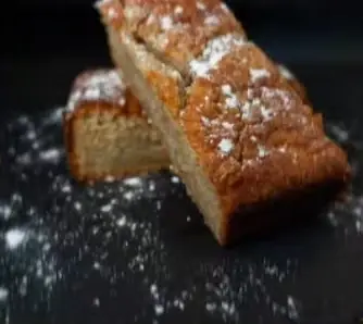 A loaf cake dusted with icing sugar