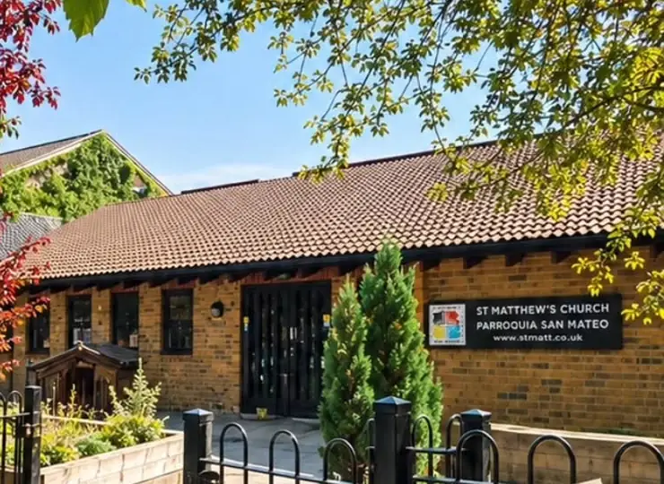 St Matthew's Church on Meadow Row: a yellow-brick building with a tiled roof, black railings and planters